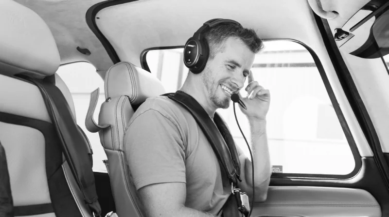 Nathan Barry smiling in a helicopter cockpit, wearing a headset